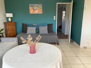 a living room with a table with a vase on it at Maison non fumeur - jardin 5 personnes proche des plages finistériennes in Guipavas