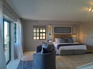 Un dormitorio con una cama, un sofá y una silla. en Settler Sands - Holsboer Vacations, en Port Alfred