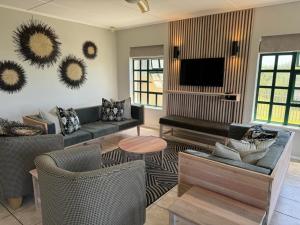 Una sala de estar con sofás y un televisor de pantalla plana. en Settler Sands - Holsboer Vacations, en Port Alfred