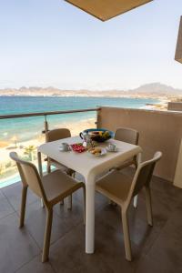 a white table and chairs with a view of the ocean at Las Rochas Mindelo Aparthotel in Mindelo