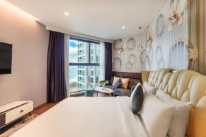 a bedroom with a large bed and a large window at Apec Mandala Mũi Né Resorts & Hotels NN in Phan Thiet