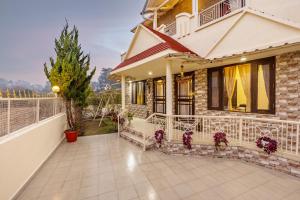 a house with a balcony and a patio at Alaya Stays Cozy Nest 2 BHK Cottage with Garden in Bhīm Tāl