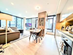 a kitchen and living room with a table and a couch at Luxurious &cozy apartment with pool and gym in Sydney CBD in Sydney