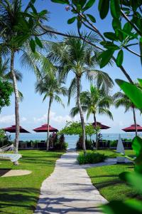a path through a park with palm trees at PARKROYAL Penang Resort in Batu Ferringhi