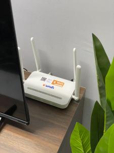 a router sitting on a desk next to a computer at Altizat Homestay - Pool ا Bbq ا Netflix ا Wifi in Melaka