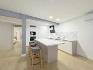 a white kitchen with a counter and stools at Amplio Apartamento con Parking y en el Centro in Almería
