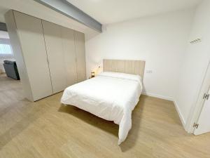 a white bedroom with a bed and a closet at Amplio Apartamento con Parking y en el Centro in Almería