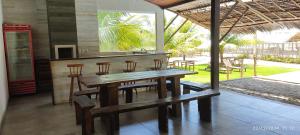 ein Esszimmer mit einem Holztisch und Stühlen in der Unterkunft Mansão Ponta da Asa in Coruripe