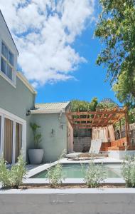a backyard with a swimming pool and a house at Best place ever - beach style cozy apartment in Cape Town