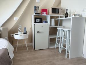 a small room with a refrigerator and a table at B&B Chapeau in Casagiove