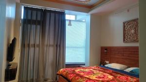 a bedroom with a bed and a large window at Starry Summit Suites in Shimla