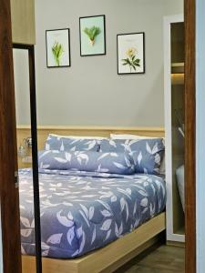 a bed in a room with three pictures on the wall at Ploy Mountain View Pool Villa in Ban Thai Thai