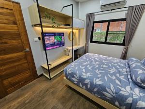 a bedroom with a bed and a tv in it at Ploy Mountain View Pool Villa in Ban Thai Thai