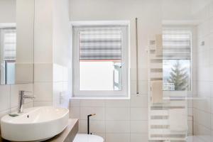 a white bathroom with a sink and a window at Ferienwohnung Tannenblick 6-2 in Oberhof +19 photos