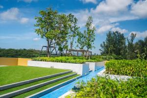 a view of a swimming pool with trees and grass at Laguna Beachside residences apartamens, walking distance to the sea in Bang Tao Beach