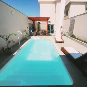 a swimming pool in the backyard of a house at Ivana Imoveis - Casa com Piscina na Praia do Morro á 2 minutos da praia in Guarapari
