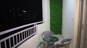 a balcony with two chairs and a table and a window at Dcasa Apartment Hotel in Hyderabad