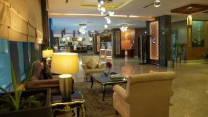 een lobby met stoelen en een tafel in een gebouw bij Golden Tulip Headington in Muscat