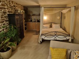 a bedroom with a canopy bed and a couch at Quinta do Brejo in Vila Cova à Coelheira