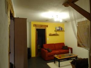 ein Wohnzimmer mit einem roten Sofa und einem Tisch in der Unterkunft Vire de Vie in Villiers