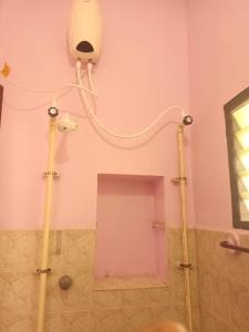 a bathroom with a shower with a light on the wall at La Vonto - Madurai Railway Junction in Madurai