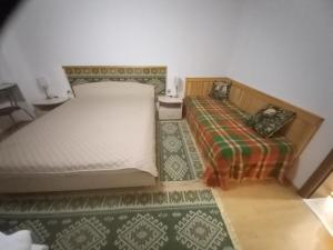 a bedroom with two beds and a green rug at Апартамент 9 in Pamporovo