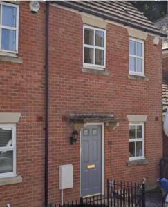 a brick house with a gray door and windows at Spacious Contractor House for Families, Groups, and Free Parking in Yeovil +5 photos