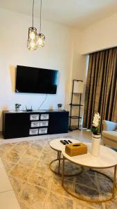 a living room with a tv and a table at MontRose residence Tower A 1BR Apartment in Dubai +4 photos