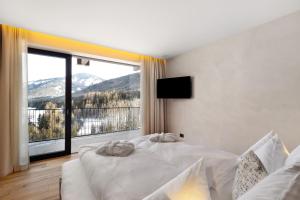 a bedroom with two beds and a large window at K Lodge View in Valdaora
