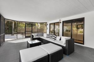 a living room with couches and tables and windows at Villa Heated Pool, Arcade games 5 min Beach in Pompano Beach