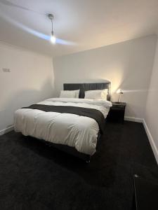 une chambre avec un grand lit avec une lumière dessus dans l'établissement House-Sleeps8-Parking-Garden, à Leeds