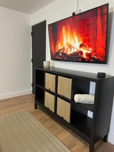 - un salon avec une cheminée et une télévision dans l'établissement House-Sleeps8-Parking-Garden, à Leeds