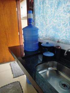 a bottle of water sitting on a counter next to a sink at Casa agradável e confortável, com piscina in Bonito +5 photos