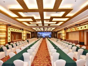 a conference hall with white chairs and a green table at Pullman Zhangjiajie Hotel - Instagrammable in Zhangjiajie