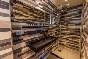 a bathroom with a black sink and striped walls at V Lofts in Amsterdam +31 photos