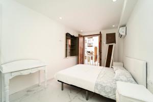 Un dormitorio blanco con una cama y un escritorio. en Villasun sunset, en Villajoyosa 17 fotos más