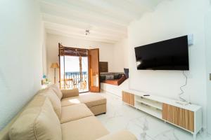 Una sala de estar con un sofá y un televisor de pantalla plana. en Villasun sunset, en Villajoyosa