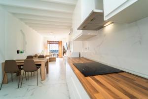 Una cocina y un comedor con mesa y sillas. en Villasun sunset, en Villajoyosa