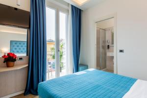 a bedroom with a bed and a large window at Hotel Italia Boutique in Rimini