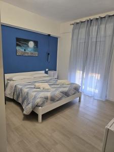 une chambre avec un grand lit avec un mur bleu dans l'établissement Vento di Mare, à Trapani