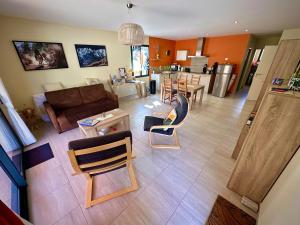 a living room with a couch and chairs and a kitchen at L'Abri de Malaucène - Gîte Cycliste in Malaucène