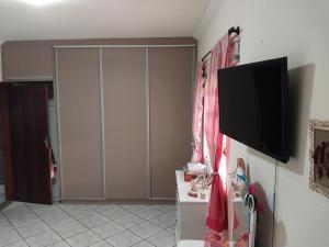 a living room with a flat screen tv on a wall at Casa Inteira in Diamantina-MG in Diamantina