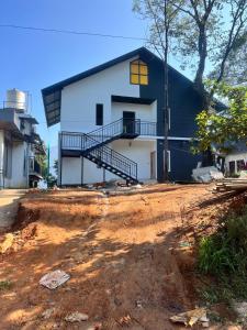 a house being constructed with a dirt road in front at The Tea Leaf Cottage in Munnar