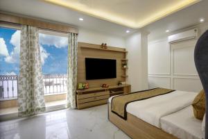 a bedroom with a bed and a tv and windows at Miyabi suites in Gurgaon +31 photos