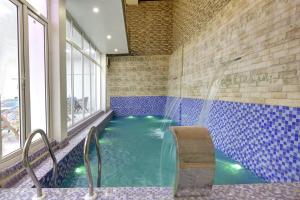 a swimming pool with a shower in a building at Miyabi suites in Gurgaon