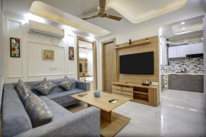 a living room with a couch and a tv at Miyabi suites in Gurgaon