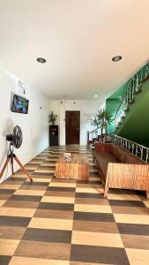 a room with a checkered floor with benches and stairs at PROpaganda Hostel in Thong Sala