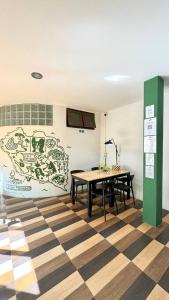 a room with a table and a wall with a mural at PROpaganda Hostel in Thong Sala