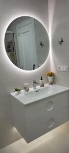 ein Badezimmer mit einem weißen Waschbecken und einem Spiegel in der Unterkunft Bungalow muy cerca de la playa in Santa Pola