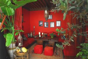 a red living room with a red couch and a fireplace at Riad La Terrasse Des Oliviers in Marrakesh